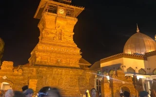 Pesona Menara Kudus Bertabur Cahaya Keemasan Malam Hari